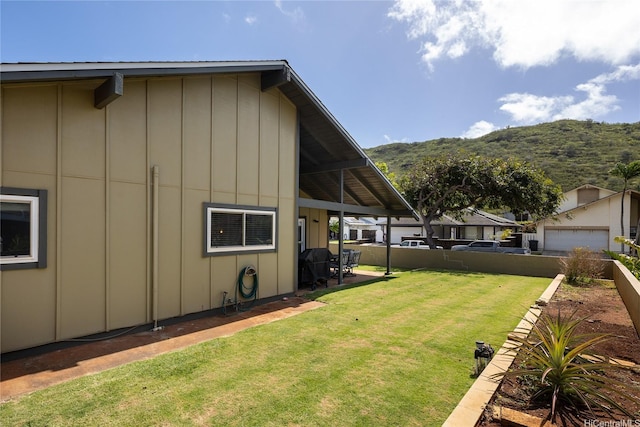 7549 Puumahoe Pl, Honolulu, HI 96825 - view of home's exterior with board and batten siding, a yard, a mountain view, and a detached garage