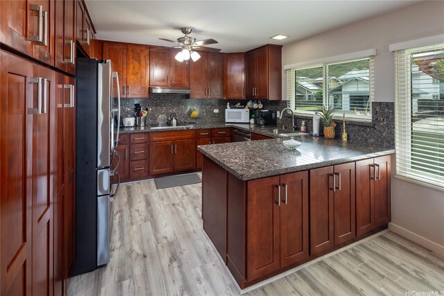 7549 Puumahoe Pl, Honolulu, HI 96825 - kitchen with freestanding refrigerator, a sink, under cabinet range hood, white microwave, and a peninsula