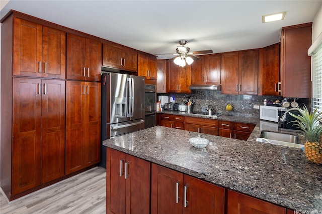 7549 Puumahoe Pl, Honolulu, HI 96825 - kitchen featuring stainless steel fridge, under cabinet range hood, dark stone counters, and a ceiling fan