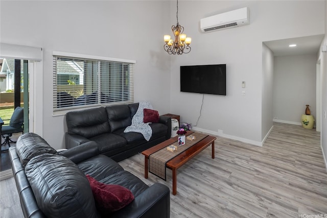 7549 Puumahoe Pl, Honolulu, HI 96825 - living area with a wall unit AC, a chandelier, light wood-style floors, baseboards, and a towering ceiling