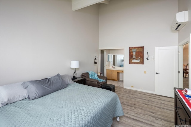 7549 Puumahoe Pl, Honolulu, HI 96825 - bedroom with a wall unit AC, a high ceiling, light wood finished floors, baseboards, and ensuite bathroom