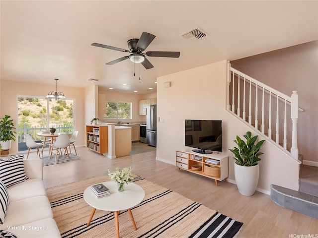 92-308 Palaulau Pl Unit 70, Kapolei, HI 96707 - living area featuring light wood-style flooring, stairway, a chandelier, a ceiling fan, and baseboards