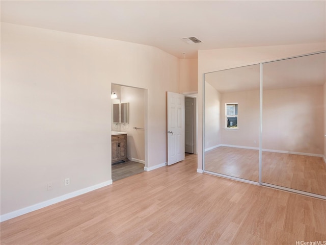 92-308 Palaulau Pl Unit 70, Kapolei, HI 96707 - unfurnished bedroom featuring vaulted ceiling, light wood-type flooring, baseboards, a closet, and ensuite bath