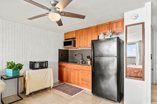 53-567 Kamehameha Hwy Unit 503, Hauula, HI 96717 - kitchen featuring freestanding refrigerator, stainless steel microwave, ceiling fan, light tile patterned flooring, and brown cabinetry