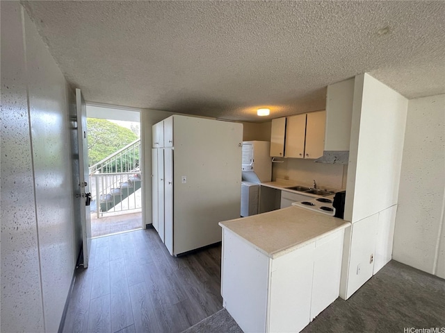95-009 Waikalani Dr Unit B202, Mililani, HI 96789 - kitchen featuring a textured ceiling, a sink, dark wood-style flooring, a peninsula, and light countertops