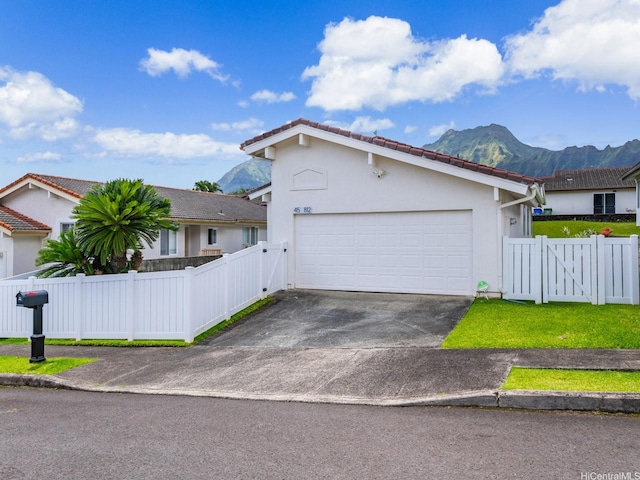 45-812 Kupohu St, Kaneohe, HI 96744 - view of front facade with a mountain view, concrete driveway, stucco siding, a tiled roof, and an attached garage