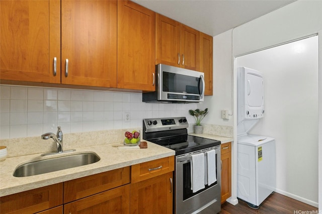 95-314 Kaloapau St Unit 122, Mililani, HI 96789 - kitchen with stainless steel appliances, stacked washer / drying machine, a sink, and brown cabinetry