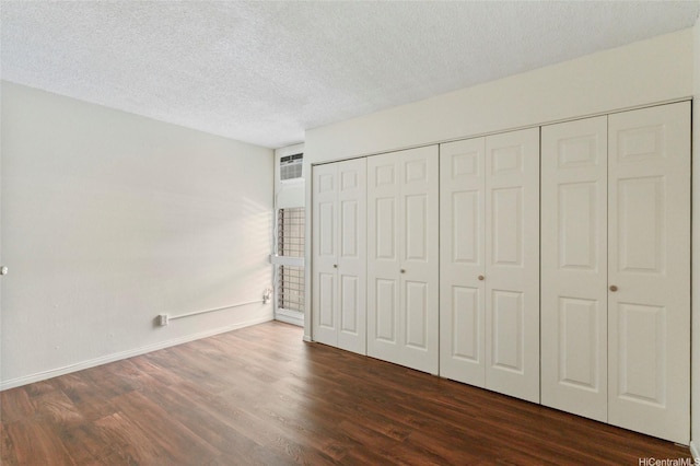 95-314 Kaloapau St Unit 122, Mililani, HI 96789 - unfurnished bedroom featuring dark wood-type flooring, a textured ceiling, and baseboards
