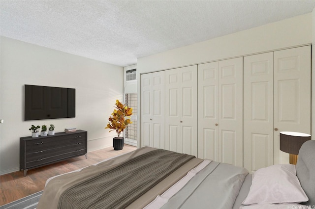95-314 Kaloapau St Unit 122, Mililani, HI 96789 - bedroom featuring wood finished floors, a textured ceiling, a closet, and baseboards