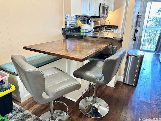 1023 Kapahulu Ave Unit 1, Honolulu, HI 96816 - kitchen featuring stainless steel microwave, dark wood-type flooring, backsplash, and baseboards