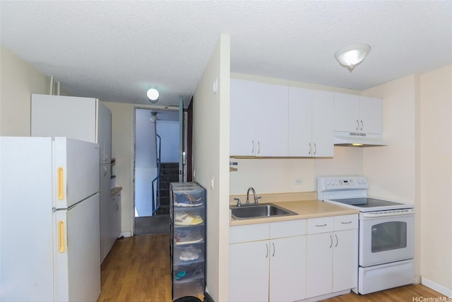 1718 Anapuni St Unit 205, Honolulu, HI 96822 - kitchen with white appliances, under cabinet range hood, a sink, light wood-type flooring, and a textured ceiling