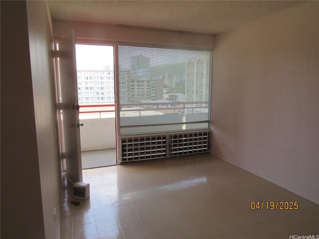 1670 Kalakaua Ave Unit 603, Honolulu, HI 96826 - spare room with radiator heating unit and a textured ceiling