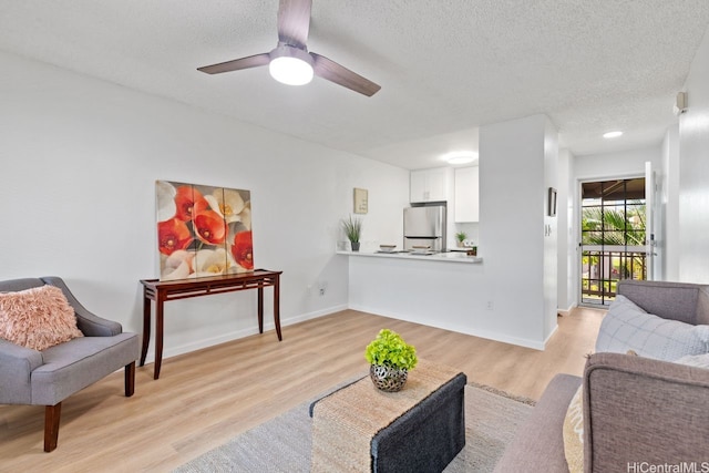 94-870 Lumiauau St Unit T203, Waipahu, HI 96797 - living area featuring light wood-type flooring, a textured ceiling, a ceiling fan, and baseboards