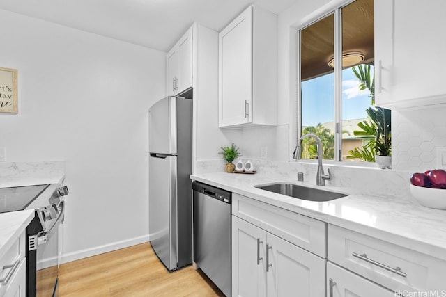 94-870 Lumiauau St Unit T203, Waipahu, HI 96797 - kitchen featuring appliances with stainless steel finishes, a sink, white cabinetry, light wood-style flooring, and light stone countertops