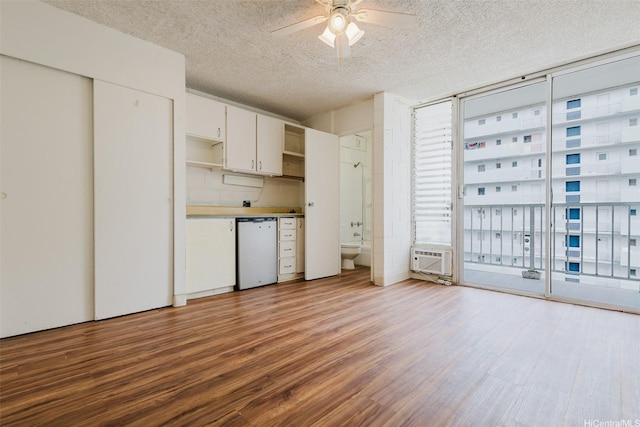 2509 Ala Wai Blvd Unit 804, Honolulu, HI 96815 - unfurnished living room featuring wood finished floors, a ceiling fan, a textured ceiling, and a wall mounted AC