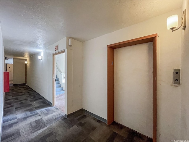 2509 Ala Wai Blvd Unit 804, Honolulu, HI 96815 - corridor with a textured ceiling, dark colored carpet, elevator, and stairs