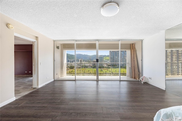 430 Keoniana St Unit 1007, Honolulu, HI 96815 - unfurnished living room with floor to ceiling windows, wood finished floors, a textured ceiling, and a mountain view