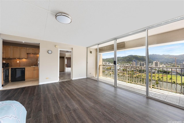 430 Keoniana St Unit 1007, Honolulu, HI 96815 - unfurnished living room featuring wood finished floors, a mountain view, baseboards, and floor to ceiling windows
