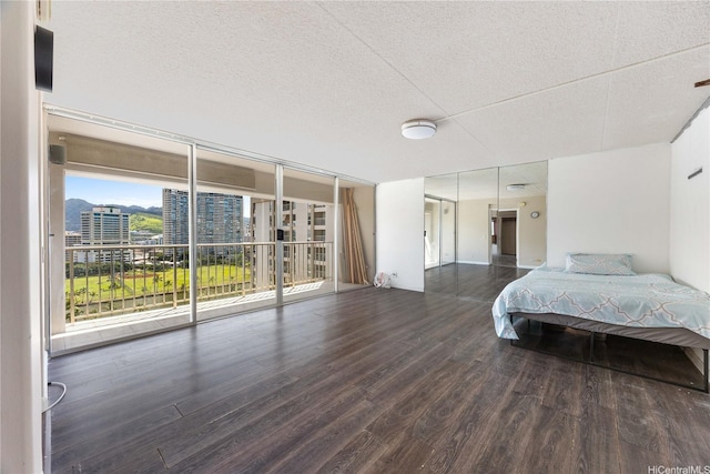 430 Keoniana St Unit 1007, Honolulu, HI 96815 - bedroom with wood finished floors, access to exterior, a textured ceiling, and a city view