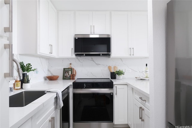 98-501 Koauka Loop Unit A1006, Aiea, HI 96701 - kitchen featuring electric stove, stainless steel refrigerator, white cabinetry, and decorative backsplash