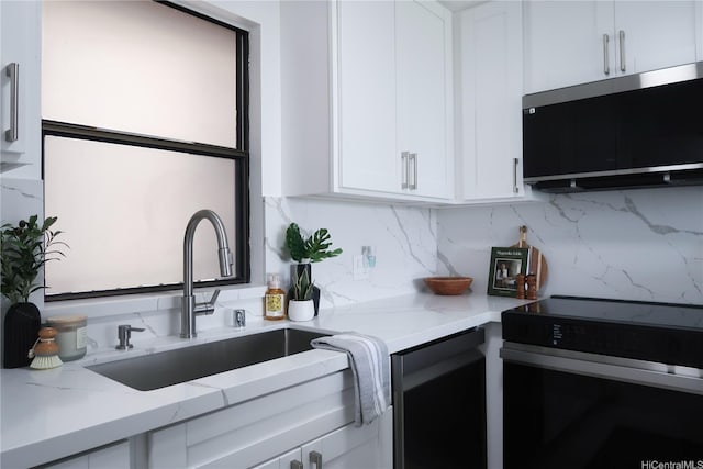 98-501 Koauka Loop Unit A1006, Aiea, HI 96701 - kitchen with range with electric stovetop, a sink, white cabinets, light stone countertops, and decorative backsplash