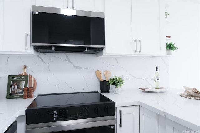 98-501 Koauka Loop Unit A1006, Aiea, HI 96701 - kitchen with range with electric stovetop, stainless steel microwave, and white cabinetry