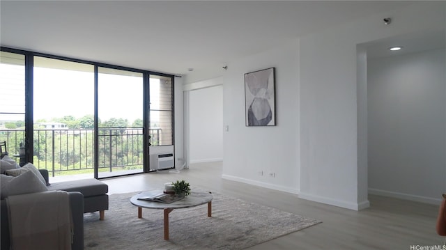 98-501 Koauka Loop Unit A1006, Aiea, HI 96701 - living area featuring floor to ceiling windows, plenty of natural light, wood finished floors, baseboards, and a wall unit AC