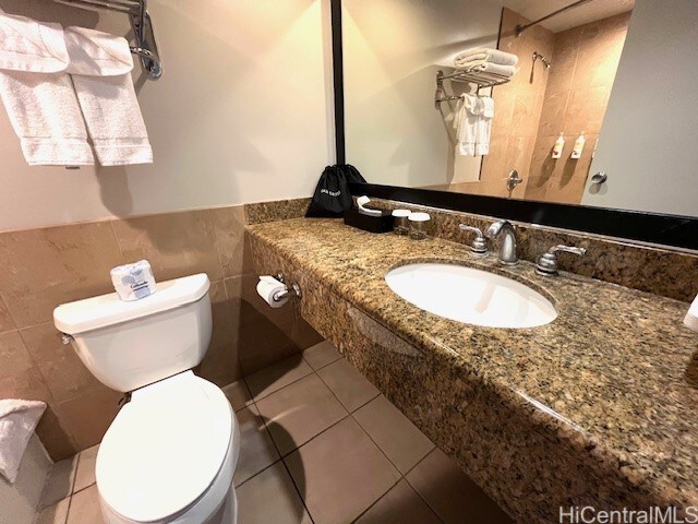 1850 Ala Moana Blvd Unit 1007, Honolulu, HI 96815 - bathroom featuring toilet, tile walls, tile patterned floors, a shower, and a wainscoted wall