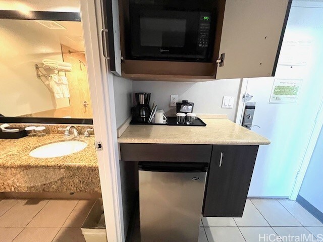 1850 Ala Moana Blvd Unit 1007, Honolulu, HI 96815 - bar with black microwave, light tile patterned floors, and a sink