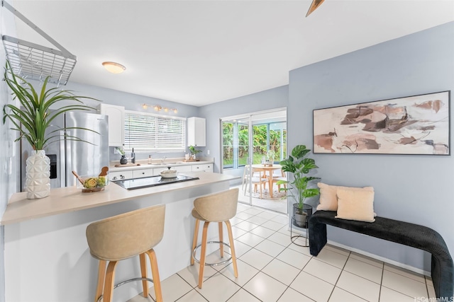 47-612 Hui Kelu St, Kaneohe, HI 96744 - kitchen featuring a kitchen bar, black electric cooktop, white cabinets, stainless steel fridge with ice dispenser, and light countertops