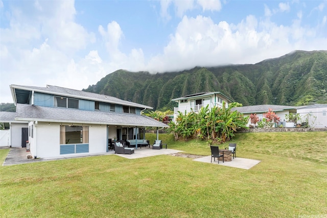 47-612 Hui Kelu St, Kaneohe, HI 96744 - back of property with an outdoor living space with a fire pit, a patio area, a mountain view, stucco siding, and a yard
