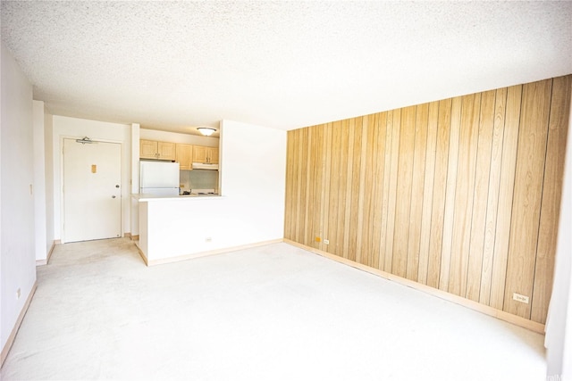 725 Piikoi St Unit 405, Honolulu, HI 96814 - unfurnished living room with wood walls, light carpet, a textured ceiling, and baseboards