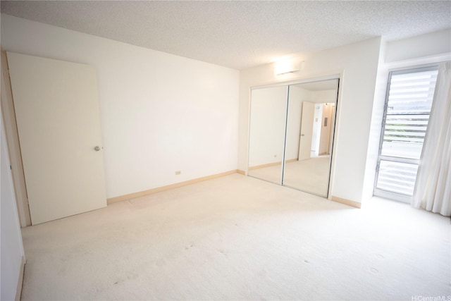 725 Piikoi St Unit 405, Honolulu, HI 96814 - unfurnished bedroom featuring light carpet, a closet, a textured ceiling, and baseboards
