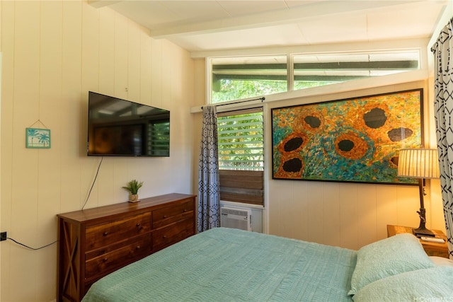 bedroom featuring beam ceiling and wooden walls