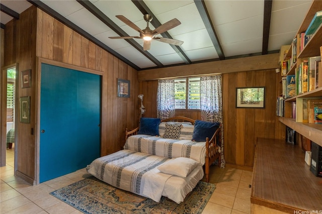 sitting room with wooden walls, light tile patterned flooring, and a ceiling fan