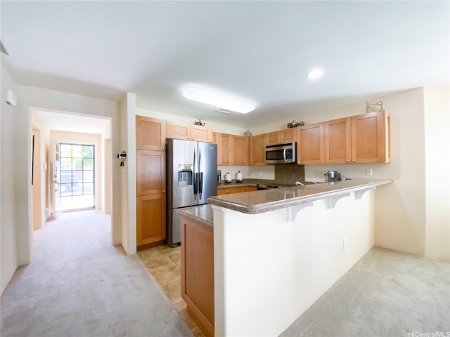91-1775 Waiaama St, Ewa Beach, HI 96706 - kitchen with stainless steel appliances, light colored carpet, a peninsula, and a breakfast bar area