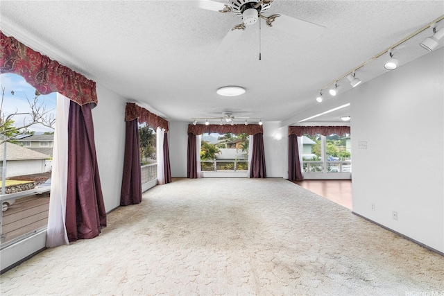 94-046 Puanane Pl, Mililani, HI 96789 - carpeted empty room with a ceiling fan, a textured ceiling, plenty of natural light, and track lighting
