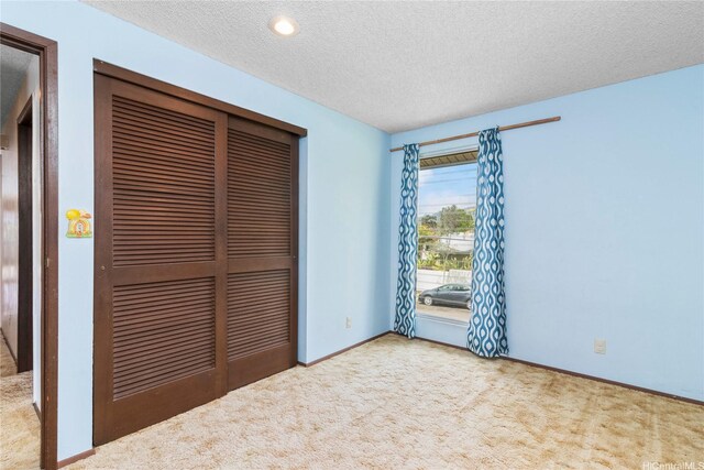 94-046 Puanane Pl, Mililani, HI 96789 - unfurnished bedroom featuring carpet floors, a closet, a textured ceiling, and baseboards
