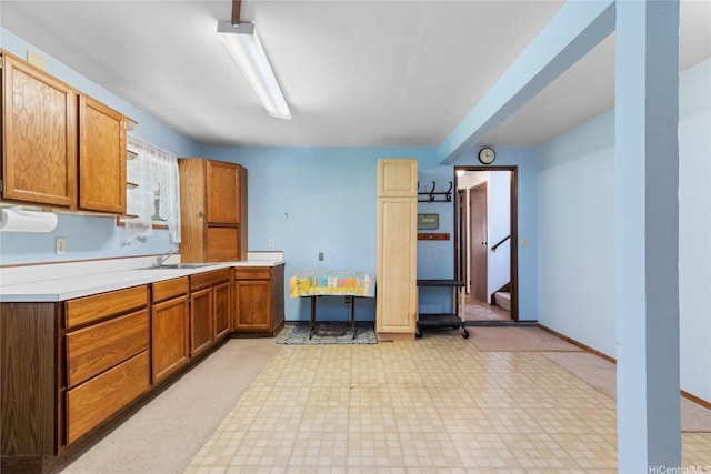 94-046 Puanane Pl, Mililani, HI 96789 - kitchen featuring a sink, light countertops, baseboards, brown cabinets, and light flooring