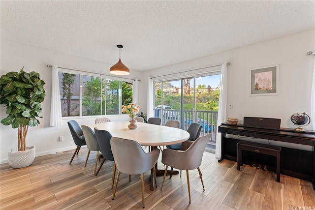 2290 Akepa St, Pearl City, HI 96782 - dining area with light wood-type flooring, a textured ceiling, and baseboards