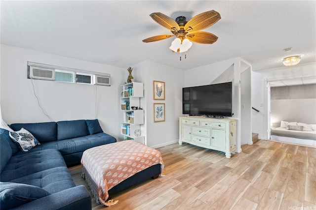 2290 Akepa St, Pearl City, HI 96782 - living room featuring light wood-style floors, ceiling fan, baseboards, a wall mounted AC, and a textured ceiling