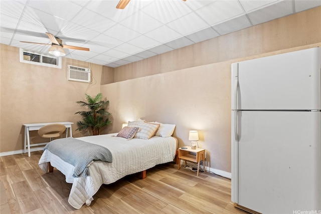 2290 Akepa St, Pearl City, HI 96782 - bedroom with freestanding refrigerator, a wall mounted AC, light wood-style floors, baseboards, and a paneled ceiling