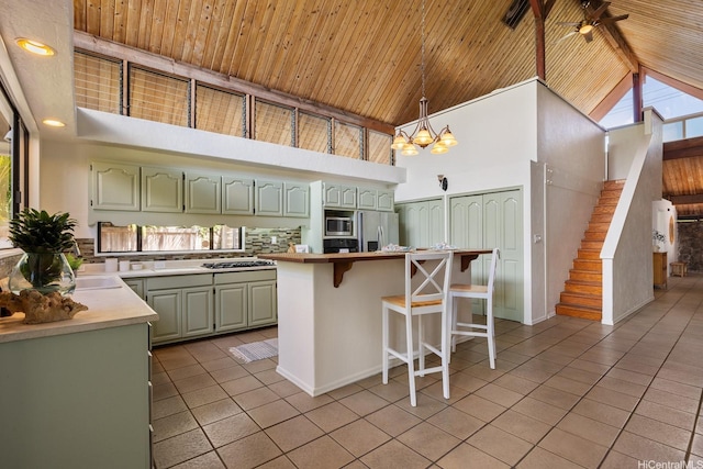 337 Wanaao Rd, Kailua, HI 96734 - kitchen with high vaulted ceiling, light tile patterned flooring, green cabinetry, a kitchen breakfast bar, and a chandelier