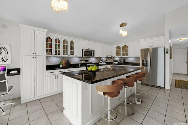 91-127 Puaina Pl, Ewa Beach, HI 96706 - kitchen featuring appliances with stainless steel finishes, light tile patterned floors, dark countertops, decorative backsplash, and vaulted ceiling