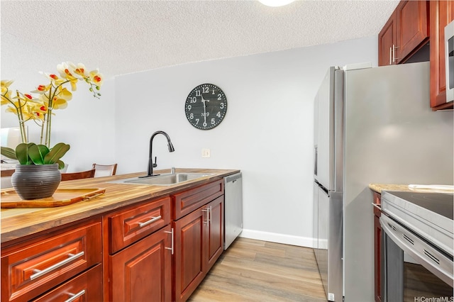 60 N Beretania St Unit 3308, Honolulu, HI 96817 - kitchen featuring stainless steel dishwasher, a sink, a textured ceiling, wooden counters, and light wood-style flooring