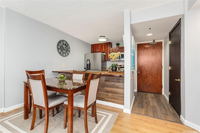 60 N Beretania St Unit 3308, Honolulu, HI 96817 - dining area with light wood-type flooring, a textured ceiling, and baseboards