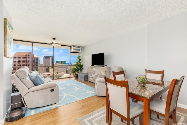 60 N Beretania St Unit 3308, Honolulu, HI 96817 - dining room with wood finished floors, expansive windows, a wall unit AC, a textured ceiling, and ceiling fan