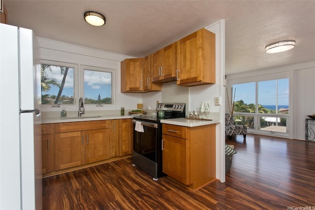92-675 Wainohia Pl, Kapolei, HI 96707 - kitchen featuring electric stove, freestanding refrigerator, a sink, brown cabinets, and dark wood finished floors