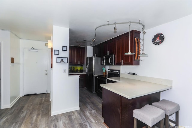 3161 Ala Ilima St Unit 206, Honolulu, HI 96818 - kitchen with stainless steel microwave, black electric range, dark wood-style floors, a kitchen breakfast bar, and a peninsula