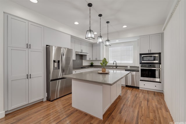 91-1067 Hoomahana St, Ewa Beach, HI 96706 - kitchen with appliances with stainless steel finishes, a center island, a sink, hanging light fixtures, and light wood-type flooring